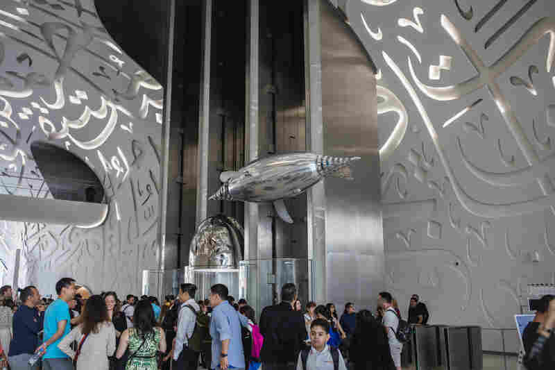 A flying robot above visitors inside the main entrance of the Museum of the Future.